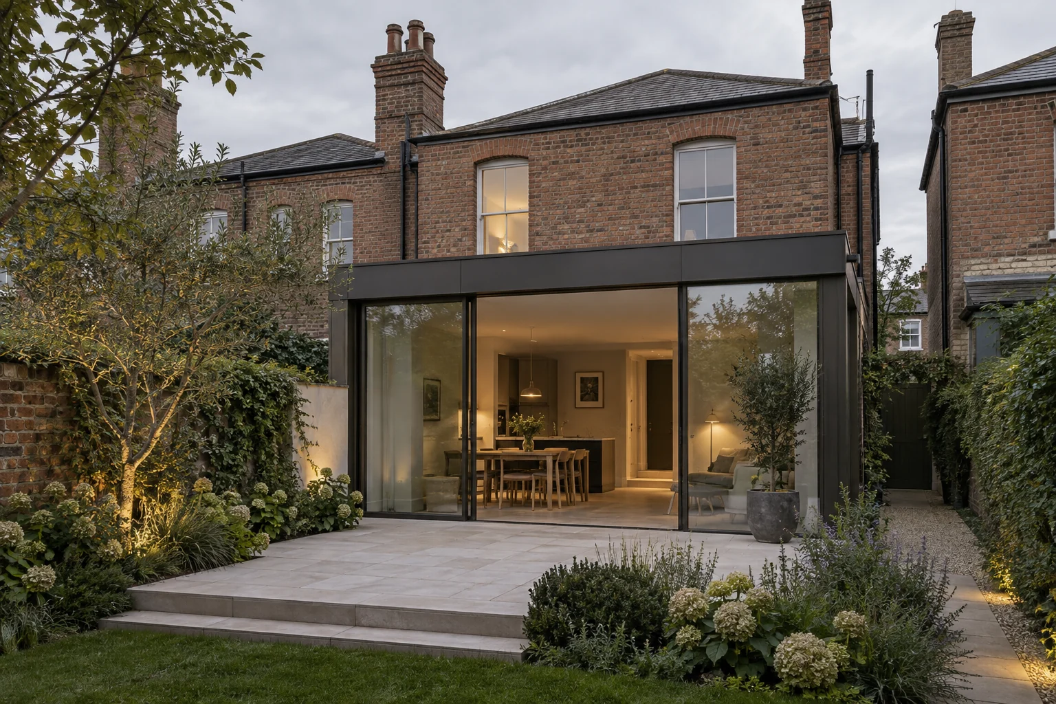Rear of a Victorian redbrick house with a single-storey glazed extension and a small garden
